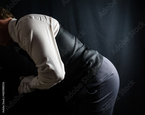 Profile Portrait of Butler or Servant Bowing Courteously. At Your Service Concept. Professional Hospitality.