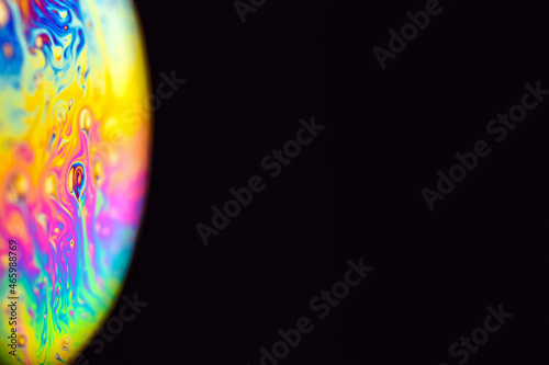 Abstract multicolor psychedelic planet. Closeup Soap bubble like an alien planet on dark background