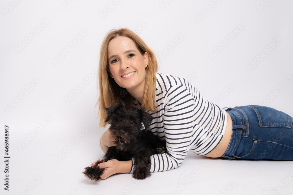 Young smiling woman lying on the floor embracing her dog isolated over white background. Young smiling woman lying on the floor embracing her dog isolated over white background.