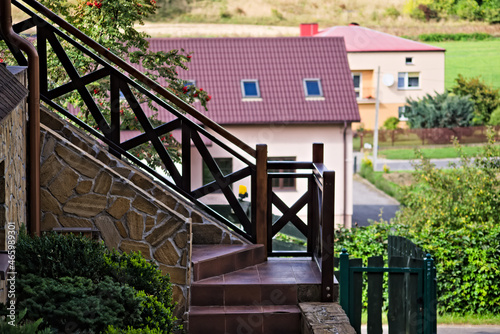 Kamienne schody z drewnianą poręczą . Dom na wzgórzu . Stone stairs with a wooden rail. House on the hill.
