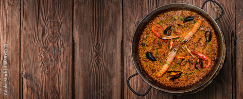 Seafood paella on rustic wood on banner format photo