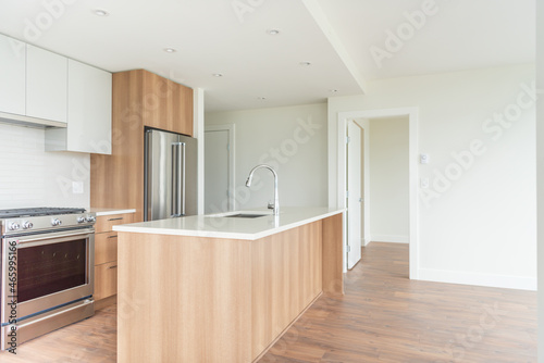 Modern, bright, clean empty kitchen interior with stainless steel appliances in a luxury house.