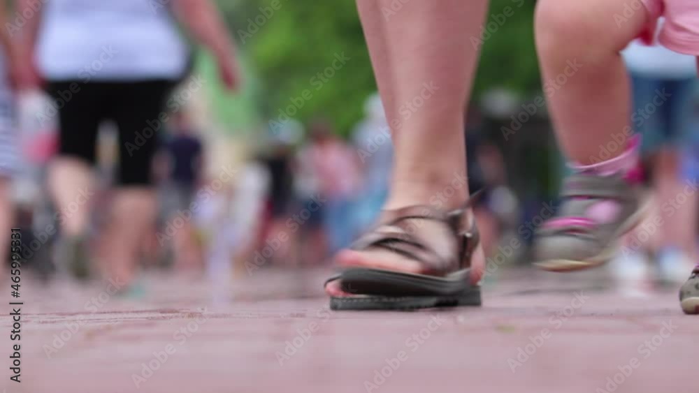 Defocused video - legs of people walking along the embankment in the seaside city. Tourists and vacationers. Defocused video - legs of people walking along the embankment in the seaside city. Tourists and vacationers.