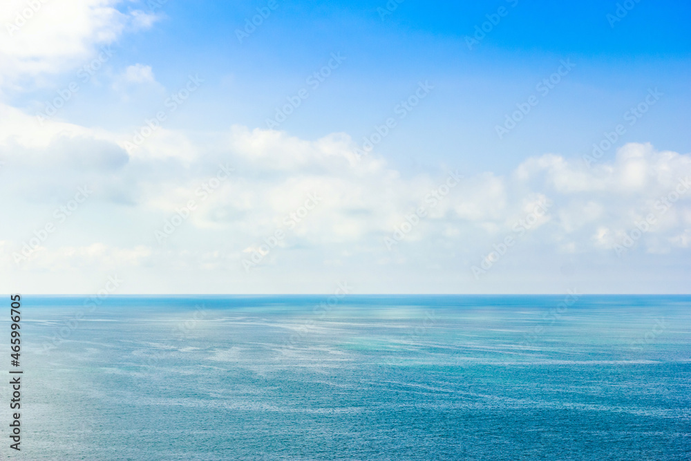 View of the calm sea and small clouds in the distance