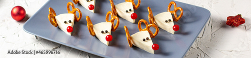 banner of Funny christmas snack in a shapes of deer for kids party. Concept New year food from cheese and pretzels