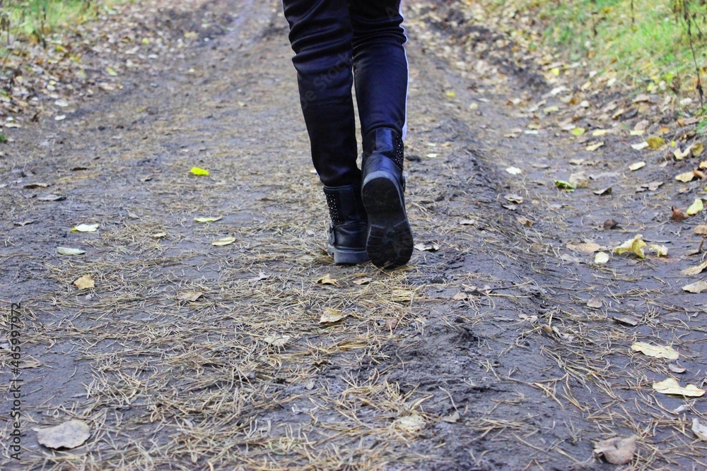 Walking or running with your feet on the trail, Hiking in the fall on the road in a secluded autumn forest with fallen yellow leaves. Green concepts. Travelers are walking. space for writing text on a Walking or running with your feet on the trail, Hiking in the fall on the road in a secluded autumn forest with fallen yellow leaves. Green concepts. Travelers are walking. space for writing text on a