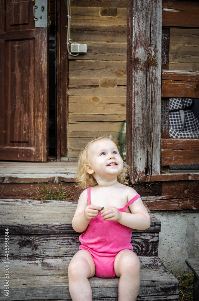 Fototapeta premium Little girl, blonde, in a pink summer suit