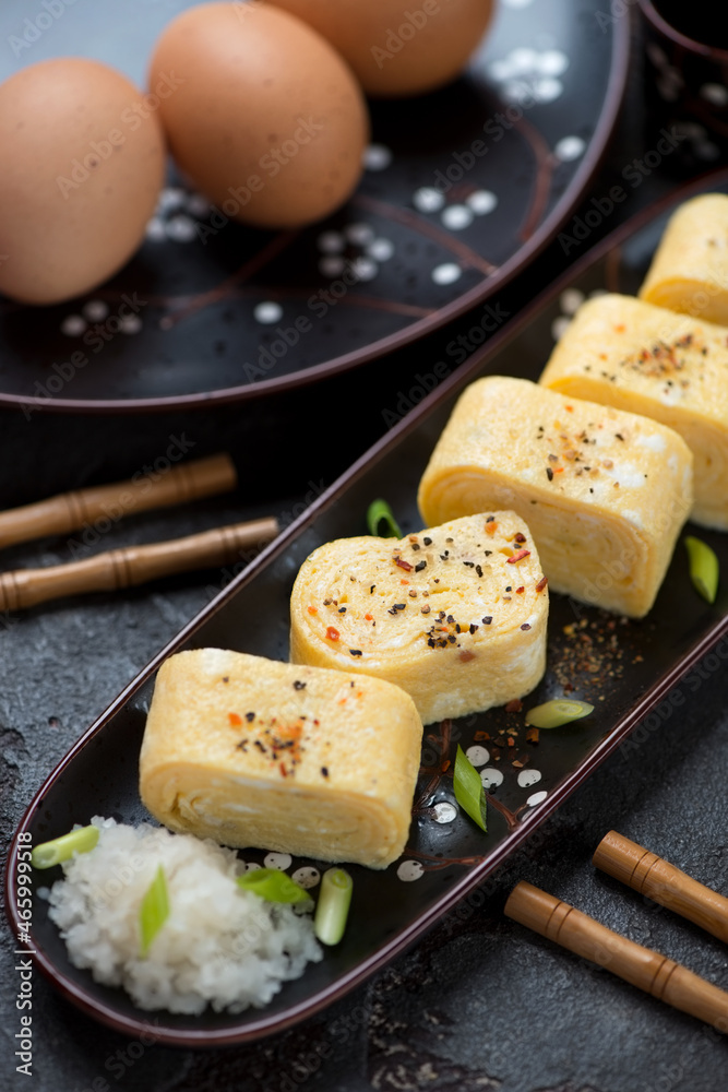 Middle close-up of sliced tamagoyaki or japanese rolled omelette, vertical shot, selective focus Middle close-up of sliced tamagoyaki or japanese rolled omelette, vertical shot, selective focus