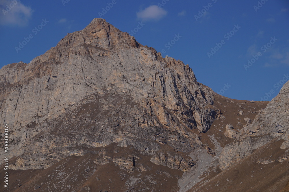 Mountain view on a clear autumn day. Mountains in Ingushetia. Landscape in the mountains in autumn. Rocks and trees in a mountainous area. 