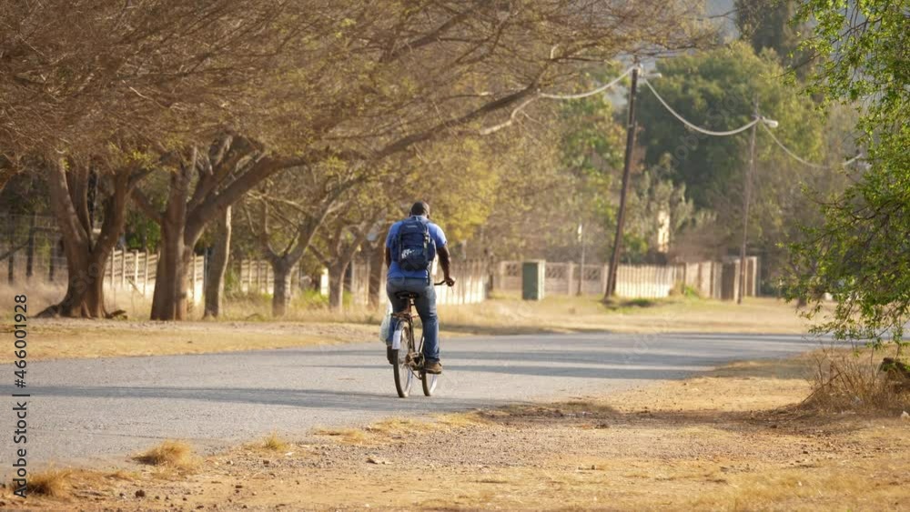 local man riding his bicycle through a neighborhood