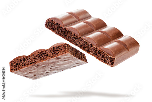 Bars of porous milk chocolate falling on a white background. Isolated photo