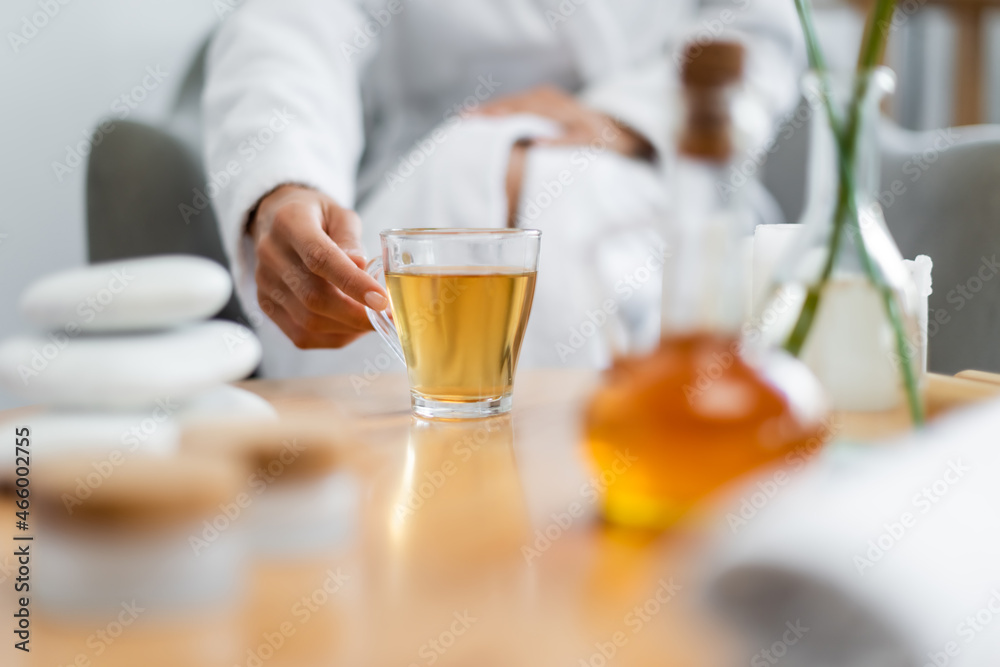 cropped view of woman reaching glass cup of tea