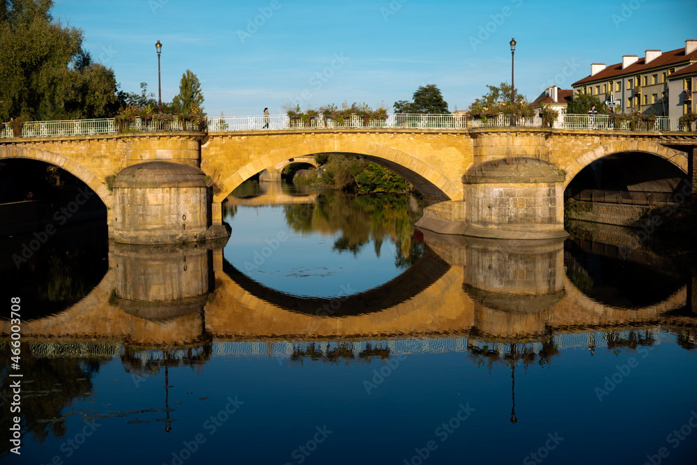 Fototapeta premium Historic bridge ,moyen pont over the Seille river in Metz France with mirror reflection on the water