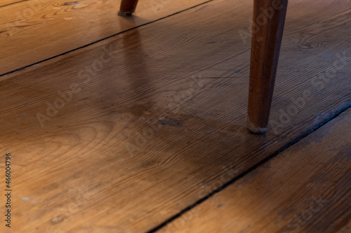 -azsscgbutt vib zwei Stuhlbeine eines alten Sessels aus den 50er Jahren auf blank polliertem Fußboden aus Holz,