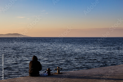 Person sitting and looking at the sunset in burgazada Istanbul, turkey photo
