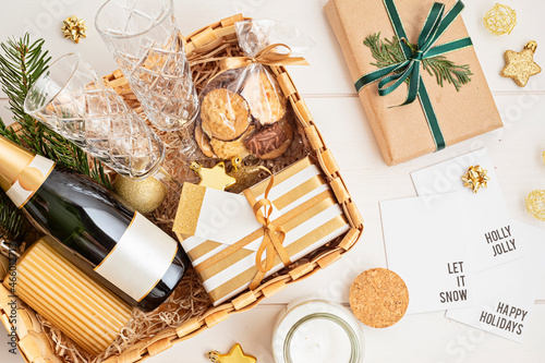 Fotografía Refined Christmas gift basket for romantic holidays with bottle of champagne, wine glasses, cookies and candle