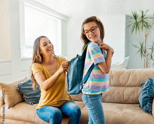 Fotografija child mother family education school girl home daughter backpack help parent get