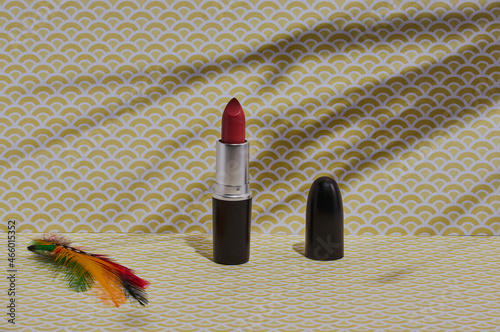 Lipstick on a patterned background, with tree shadows in the background. photo