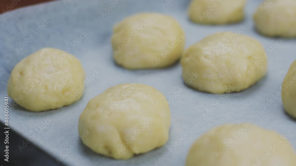 Preparing homemade sweet buns dough. A person preparing raw buns for baking. Woman making traditional buns. Cooking homemade buns Preparing homemade sweet buns dough. A person preparing raw buns for baking. Woman making traditional buns. Cooking homemade buns