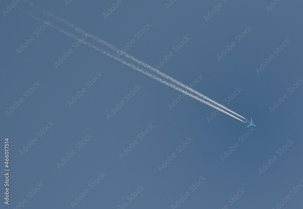 Avion et sa trainée de condensation dans un ciel bleu Avion et sa trainée de condensation dans un ciel bleu
