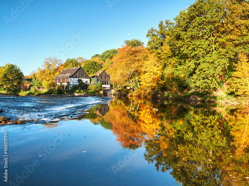 Fototapeta Naklejka Na Ścianę i Meble -  Half-timbered houses on the river bank. View on the Wipperkotten on the Wupper river. Beautiful golden autumn in Solingen in the Bergisches Land. Landscape photography