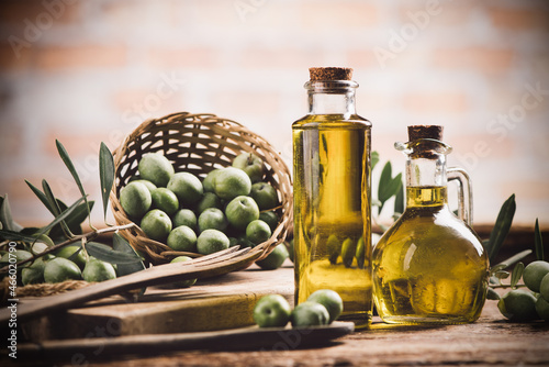 Obraz na plátně Olive oil with fresh olives on rustic wood