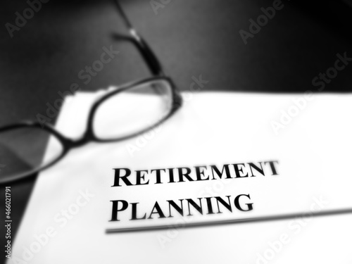 Retirement Planning Documents on Desk with Glasses Blur Focus