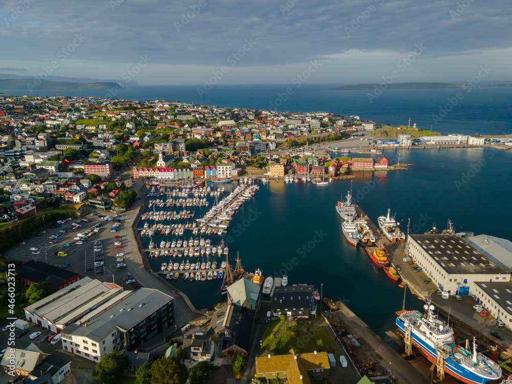 Naklejka premium Beautiful aerial view of the City of Torshavn Capital of Faroe Islands- View of Cathedral, colorful buildings, marina, suburbs and Flag