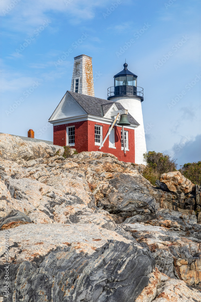 The historic Pemaquid Point Lighthouse and red fog signal bell house sit atop a beautiful granite shore above the Atlantic Ocean at Bristol, Maine.
