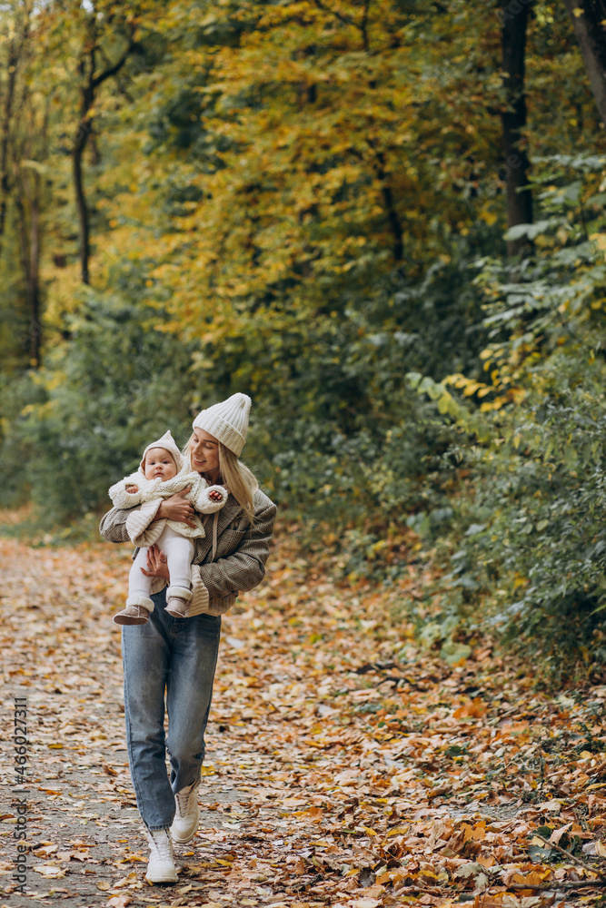 Fototapeta premium Woman with toddler child in autumn park