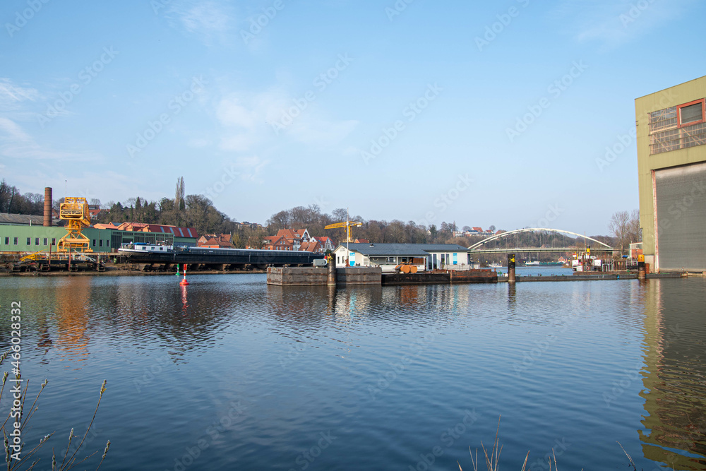 Gelber Kran, Binnenschiff und Brücke im Hafen von Lauenburg