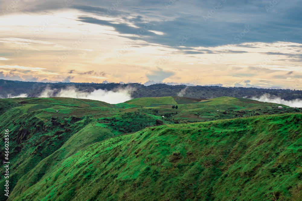 Fototapeta premium mountain valley with dramatic sunset sky and low clouds at evening