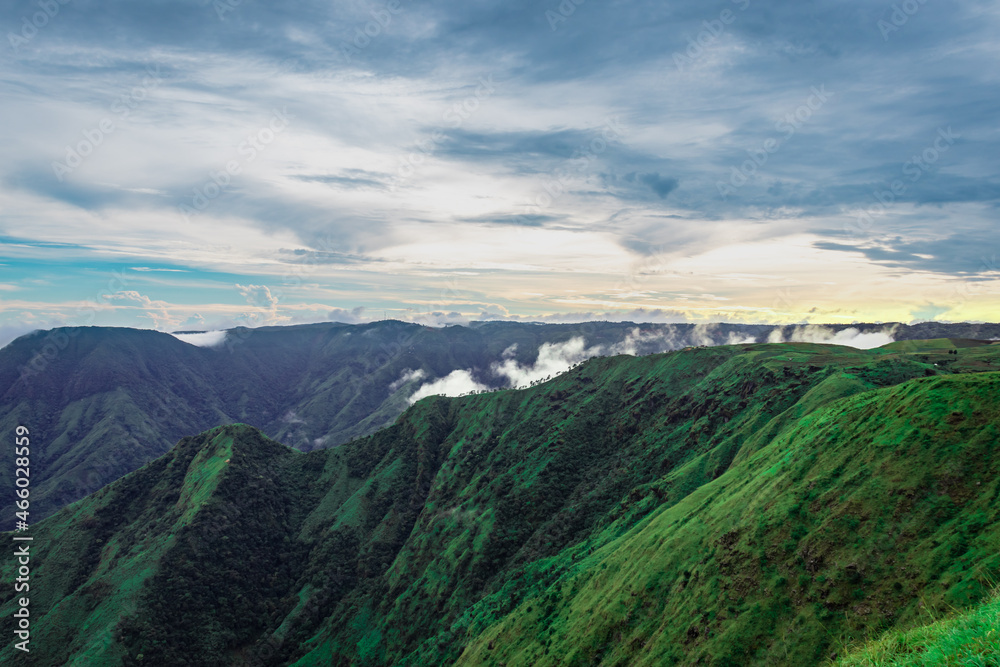 Obraz premium mountain valley with dramatic sunset sky and low clouds at evening