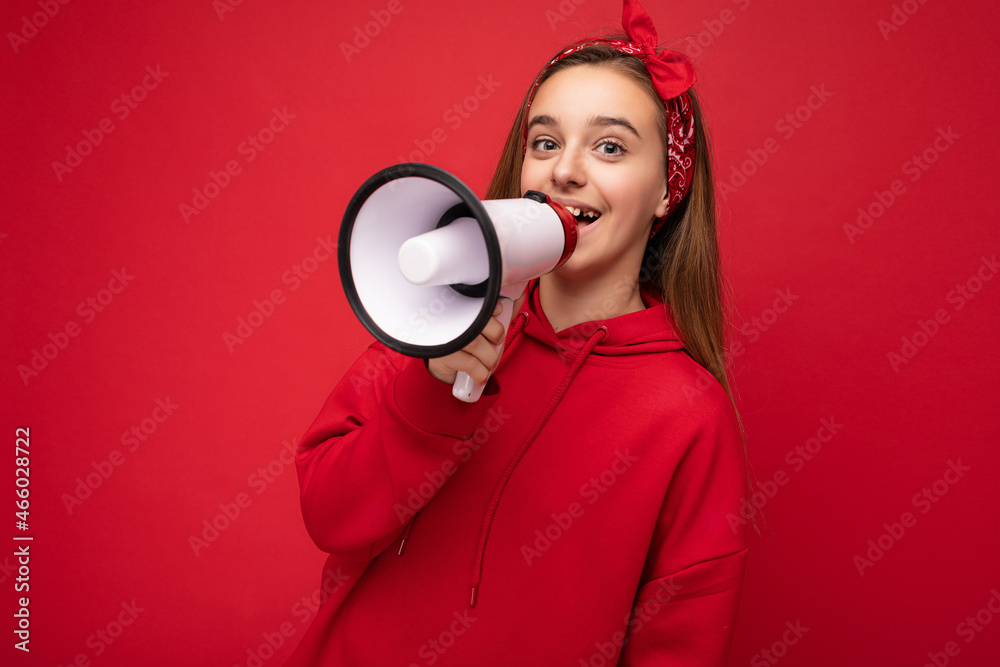 Photo shot of beautiful pretty nice positive happy smiling dark blonde little girl with sincere emotions wearing stylish red hoodie and bandanna isolated over red background with copy space and Photo shot of beautiful pretty nice positive happy smiling dark blonde little girl with sincere emotions wearing stylish red hoodie and bandanna isolated over red background with copy space and