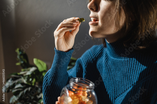 Cbd cannabis gummy - Woman eating edible weed sweet candy leaf for anxiety alternative treatment - Medical marijuana photo