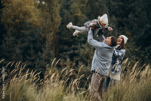 Family with little daughter together in autumnal weather having fun