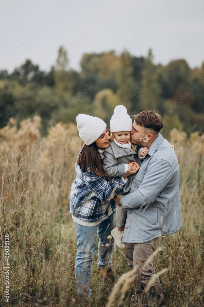 Family with little daughter together in autumnal weather having fun Family with little daughter together in autumnal weather having fun