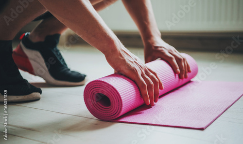 Man laying down his yoga mat. Preparing for a complex of morning exercises. Body care