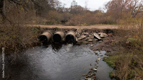 Concrete waste pipes. Streams of water flow through concrete pipes. Polluted body of water in the park. Shooting from the drone. Aerial photography. © f2014vad
