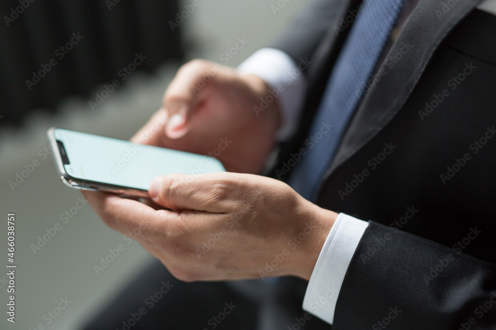 businessman man in a jacket and suit holds a smartphone in his hands. Electronics are in human hands. Concept - digital era businessman man in a jacket and suit holds a smartphone in his hands. Electronics are in human hands. Concept - digital era