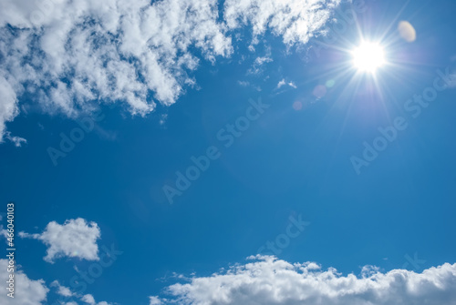 Air white clouds, sun with long rays and glare in the blue sky. Sky landscape © Андрей Иванов