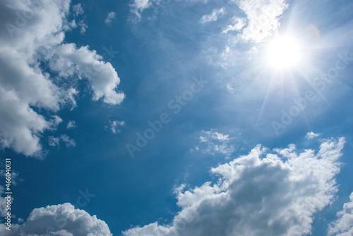 Air white clouds  sun with long rays and glare in the blue sky. Sky landscape