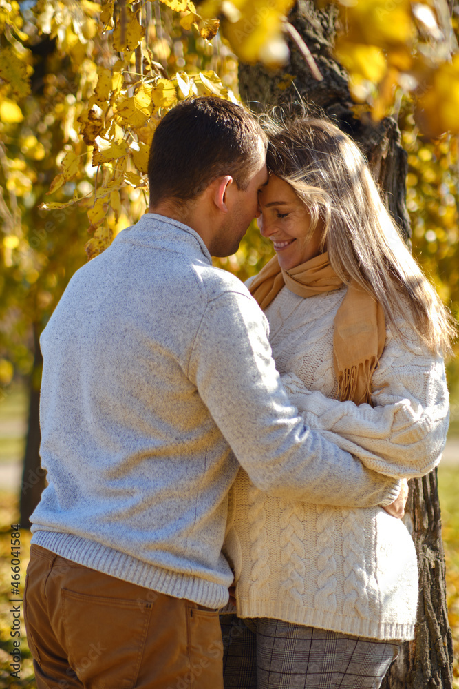 Pregnant woman and man posing at autumn park Pregnant woman and man posing at autumn park