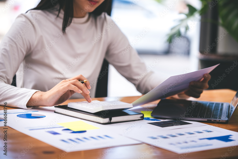 businessman or accountant who are using a calculator to calculate business data Accounting documents and laptop computer at the office business idea