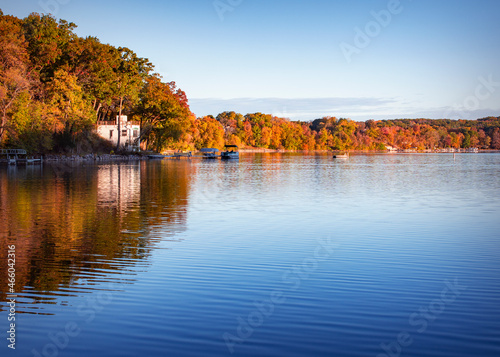 Fototapeta Naklejka Na Ścianę i Meble -  The first morning light hits the shoreline of a lake in Waukesha County, Wisconsin on a cold autumn morning.