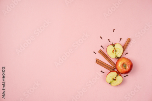 Colorful fruit composition of fresh red apples with cinnamon on pink background. Flat lay, top view, copy space for your text. Healthy concept