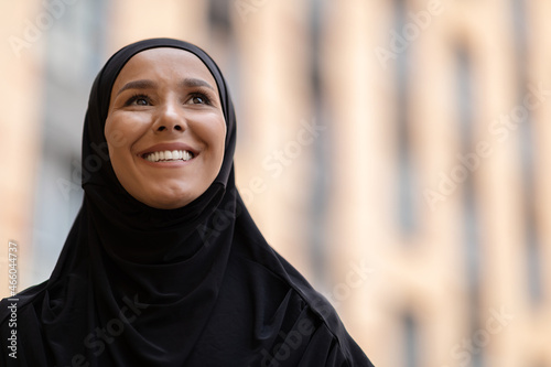 Closeup Shot Of Young Smiling Islamic Woman In Black Hijab Standing Outdoors