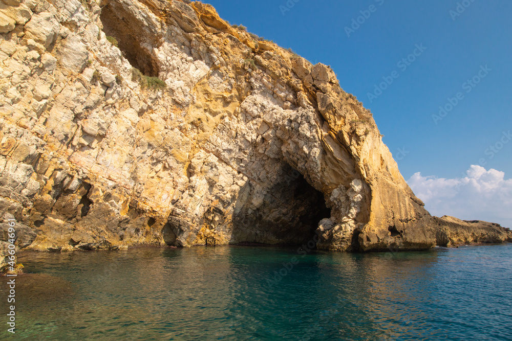Sea side view of Siracusa coast cliffs, sandstone rocks and caves in sunny summer day. A bright colorful photo good for touristic booklet or book, boat trip ads, posters etc.