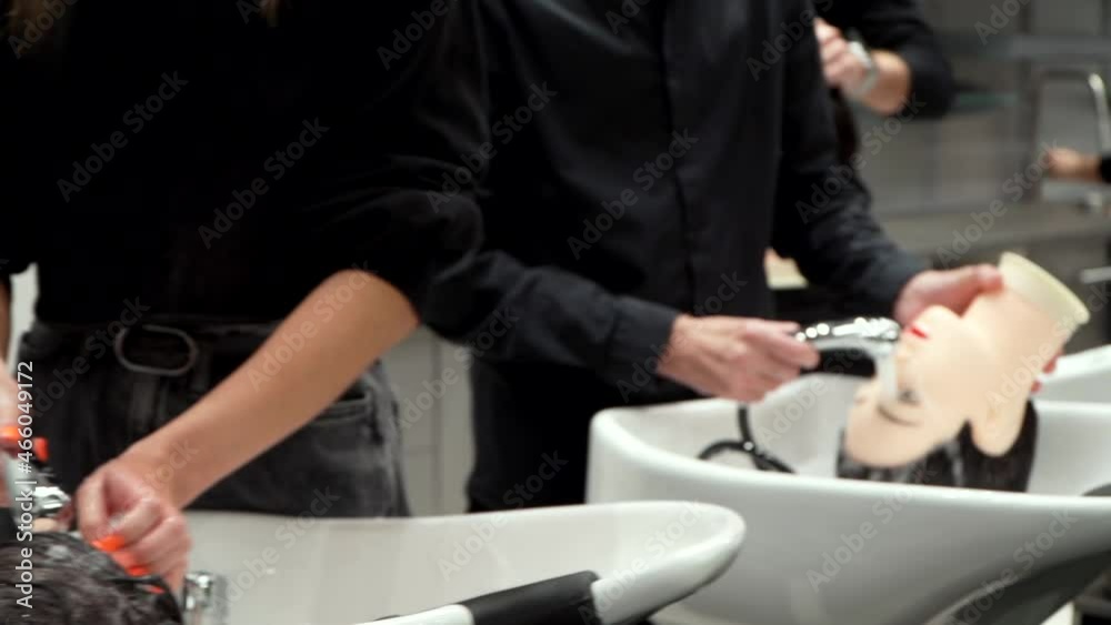 students wash the hair of mannequins at a hairdressing course Stock