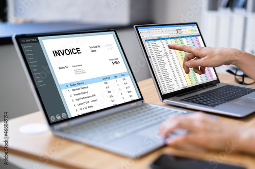 Businesswoman Looking At Invoice On Computer Screen